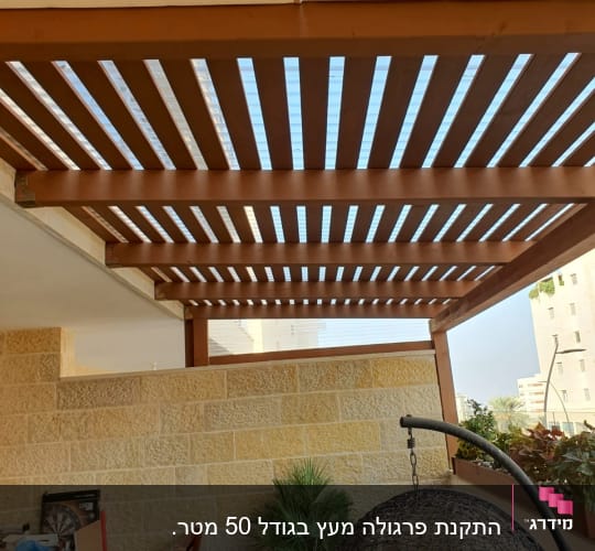 פרגולה מעץ עם צמחייה ועציץ על מרפסת